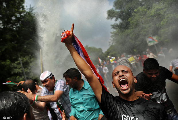 A protester shouts as he and others are hit with a police water cannon during an anti corruption protest near the Prime Minister's official residence in New Delhi, Sunday, Aug. 26, 2012. Police detained scores of anti corruption activists trying to march to the homes of top political leaders in New Delhi to protest a scandal involving the sale of coal fields without competitive bidding. (AP Photo)