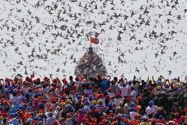 Birds are released as a crowd looks up during the parade.