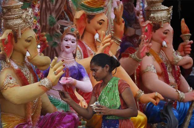 A woman giving finishing touches to an idol Lord Ganesha in Ahmadabad on the eve of Ganesh Chaturthi.