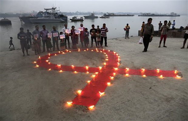 Volunteers stand with placards beside a huge red ribbon lighted with lamps during an awareness rally on AIDS day on the banks of the Ganges River in Kolkata, India (AP Photo)