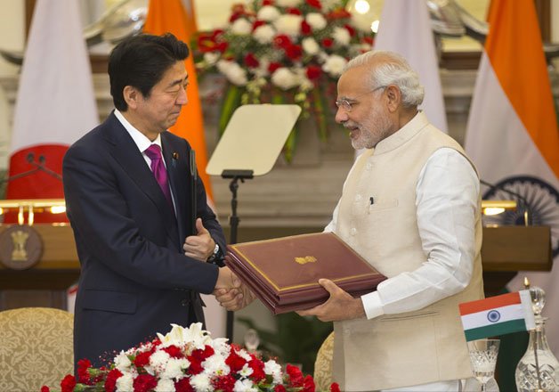 Earlier, Indian Prime Minister Narendra Modi, right, shakes hand with his Japanese counterpart Shinzo Abe after signing of agreements, in New Delhi, on Saturday.