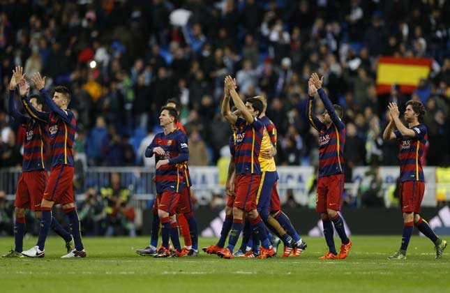 Barcelona's players celebrate their victory at the end of the first clasico of the season between Real Madrid and Barcelona at the Santiago Bernabeu stadium in Spain on Saturday. (AP Photo)
