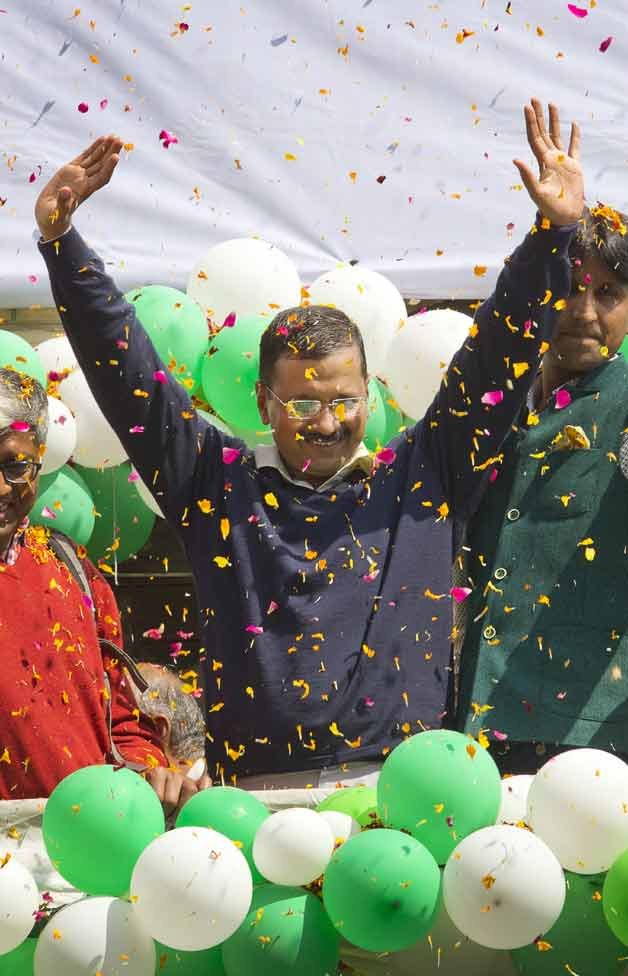 Leader of the Aam Aadmi Party, or Common Man's Party, Arvind Kejriwal waves to the crowd as his party looks set for a landslide party in New Delhi.
