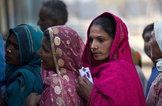 A women wait in a queue to cast their votes at a polling booth in New Delhi.