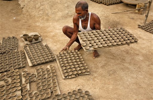 An Indian potter carries earthen lamps for drying ahead of Diwali festival in Allahabad. People buy earthen lamps to decorate their homes during the festival of lights Diwali, which will be celebrated on October 23