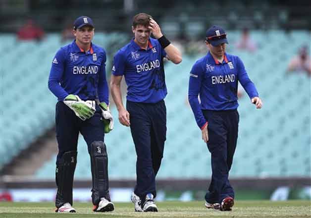 England's players from left, Jos Buttler, Chris Woakes and captain Eoin Morgan walk along the field after dismissing West Indies batsman Dwayne Smith during their Cricket World Cup warm up match in Sydney, Australia, Monday, Feb. 9, 2015.(AP Photo)