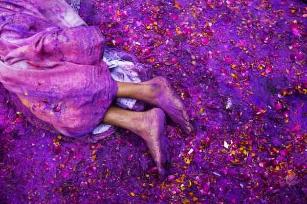 A Hindu widow lies on a sludgy ground filled with a mixture of colored powder, water and flower petals during celebrations to mark Holi at the Meera Sahabhagini Widow Ashram in Vrindavan, India.