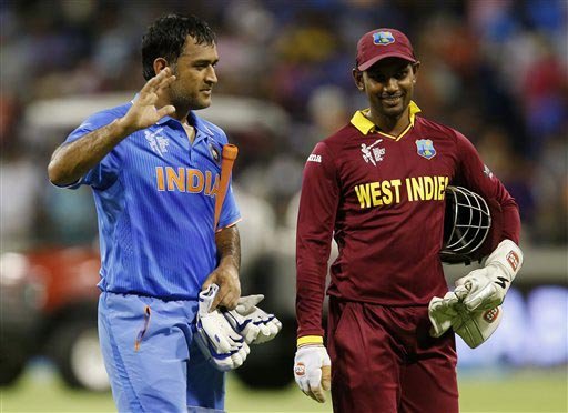 Indian captain M S Dhoni, left, waves to the crowd as he walks from the field with West Indies wicketkeeper Denesh Ramdin following their four wicket win in their Cricket World Cup Pool B match in Perth, Australia, Friday, March 6, 2015. (AP Photo)