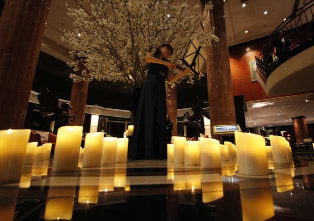 Eriko Ukimura plays the violin during the Earth Hour in Tokyo. The light at a Tokyo hotel lobby was turned off momentarily on Saturday as part of global campaign to raise awareness on environmental issues.