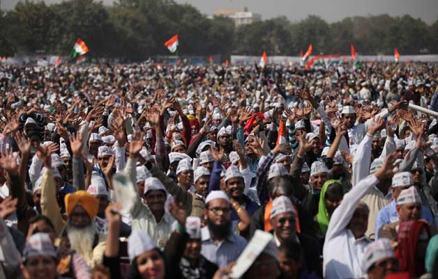Supporters of Aam Aadmi Party cheer during the swearing in ceremony of party leader Arvind Kejriwal as chief minister of Delhi in New Delhi. The AAP, headed by the former tax official who had remade himself into a champion for clean government, won 67 of the 70 seats in recent elections.