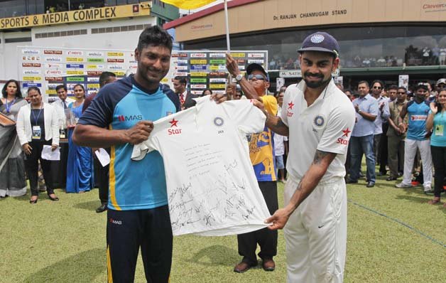 India's cricket captain Virat Kohli, right, presents a souvenir to Sri Lankan cricketer Kumar Sangakkara at the end of the second Test match in Colombo, Sri Lanka.