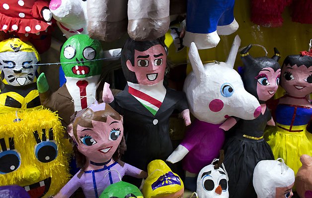A pi ata designed to resemble Mexican President Enrique Pena Nieto is displayed with other pi atas representing popular children's characters, at a La Merced market stall.