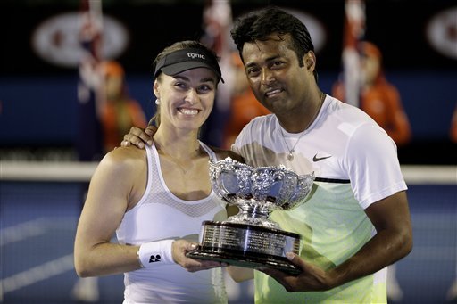 Martina Hingis of Switzerland, left, and Leander Paes of India hold trophy after defeating Kristina Mladenovic of France and Daniel Nestor of Canada in the mixed doubles final at the Australian Open tennis championship in Melbourne, Australia, Sunday, Feb. 1, 2015. (AP Photo)