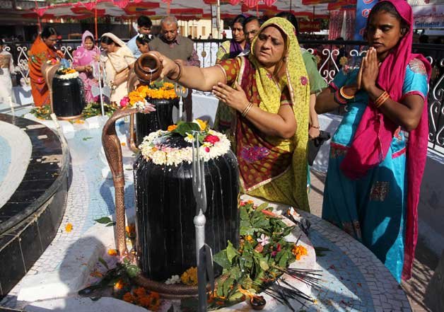 Devotees pour milk on a Shivling, an idol symbolic of Hindu god Shiva, at a temple during Shivaratri festival in Ahmadabad.