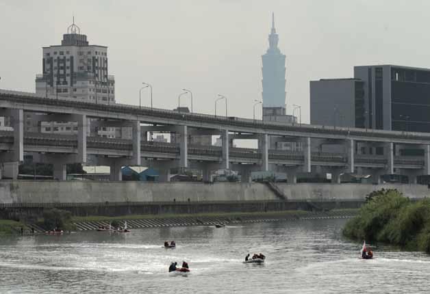 With the iconic Taipei 101 building in the background, divers on boats look for missing passengers of crashed TransAsia Airways Flight 235 in a river in Taipei, Taiwan.
