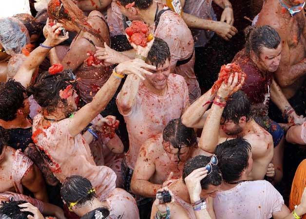 Crowds of people throw tomatoes at each other during the annual Tomatina fiesta, in the village of Bunol, 50 kilometers outside Valencia, Spain.