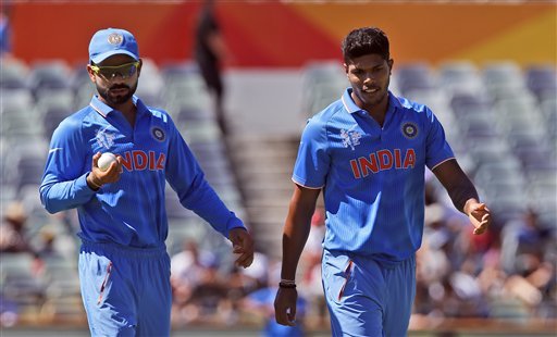 India's Virat Kohli left, looks at the ball as he walks next to bowler Umesh Yadav during their Cricket World Cup Pool B match against the United Arab Emirates in Perth, Australia, Saturday, Feb 28, 2015. (AP Photo)
